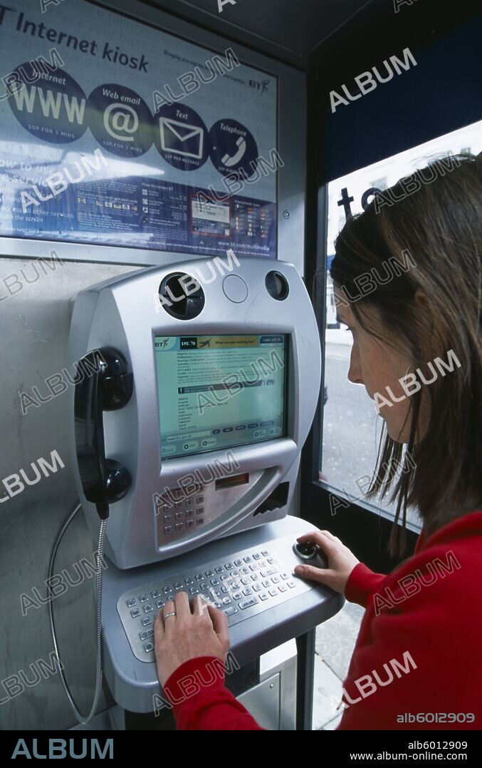 COMMUNICATIONS Phone Box Young woman using a public BT Internet phone booth.