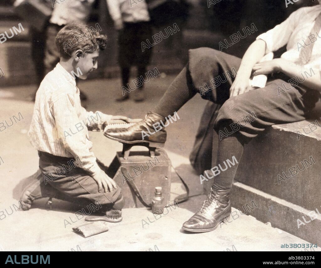 Entitled: "Bootblacks in and around City Hall Park, NYC." Shoeshiner or boot polisher is an occupation in which a person polishes shoes with shoe polish. They are often known as shoeshine boys because the job is traditionally that of a male child. Shoeshiners are often found working in business districts where professionals congregate. The shoeshiner is perceived as an informational hub, studiously polishing and buffing whilst dispensing helpful advice on local affairs and events. In 1908, Lewis Hine accepted a position as chief investigator and photographer for the National Child Labor Committee (NCLC), a private organization founded in 1904 whose mission was to promote legislation to protect children from exploitation by American industry. At the time, children as young as four years old labored in a variety of trades eight to twelve hours a day in factories, tenements, and on the streets. Photographed by Hine, July 25, 1924.