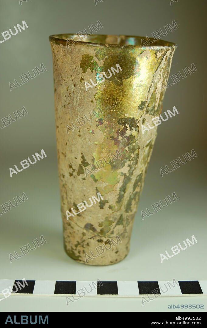Isings 106b1 of dark green glass. The soil is slightly up. No pontil brand. The straight wall runs slightly upwards. Inside and out largely covered with iris and dirt. Several fragments put together., Cup, glass, 11.5 - 11.7 cm, Roman time, Turkey.