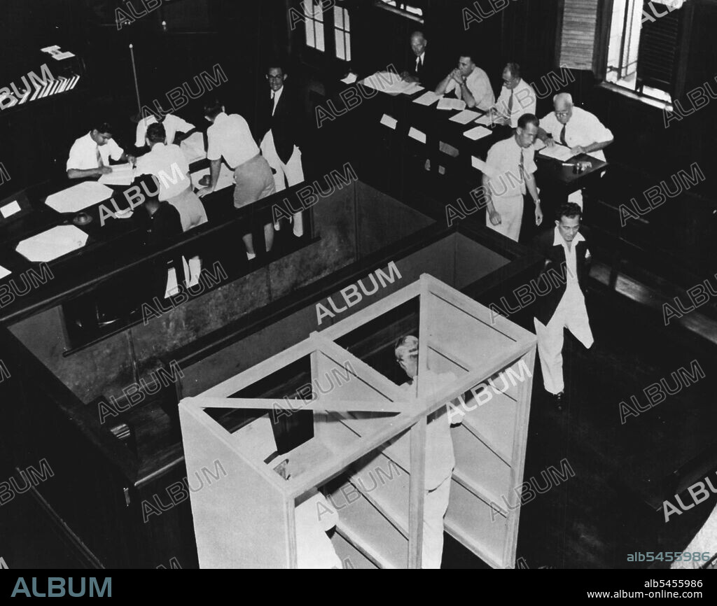 Elections In Fiji -- The European Polling Station at Suva. The candidates agents check off voters as they receive their ballot papers. The voting booth is erected behind the capacious dock of the Supreme Court.  July 11, 1951. (Photo by British Official Photograph).