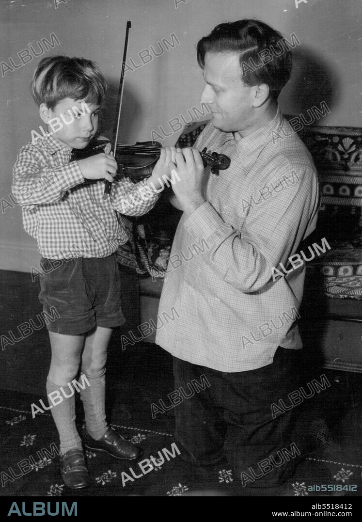 He Should Be Good On That Violin -- If he takes after his Dad.
Young man with the Violin is 6-year-old Gerard Menuhin, son of world-famous violinist Yehudi Menuhin.
Dad is giving Gerard a violin lesson at their London Hotel.
Yehudi Menuhin is here to give recitals. December 12, 1954. (Photo by Paul Popper, Paul Popper Ltd.).