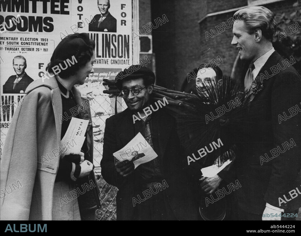 Young Conservative Fights In Red District Winning The Sweep -- Mr. Peter Rawlinson, conservative candidate for South Hackney, London, and his wife meet Mr. Francis the sweep, while canvassing. Gangs of young communists have been trying to wreck conservative open air meetings at south hackney, London by shouting down the candidate 32 year old Peter Rawlinson. He thinks he has made big inroads into the ranks of the communist supporters who are getting worried. His No. 1 supporter is his tall slim Irish wife, Haidee, who tours the constituency in an old car. October 19, 1951. (Photo by Paul Popper Ltd.).