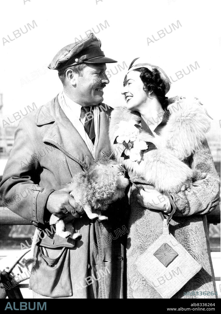 Col. Turner Greeted By Wife -- Col. Roscoe Turner, California's Airforce ace who piloted the plane which finished third in the London-Melbourne flight, is shown here as he was greeted by his wife when he reached Los Angeles, Dec. 1, on the S.S. Mariposa. He's holding the Toy Lion Mascot which he carried during the race. February 12, 1934. (Photo by Associated Press Photo).