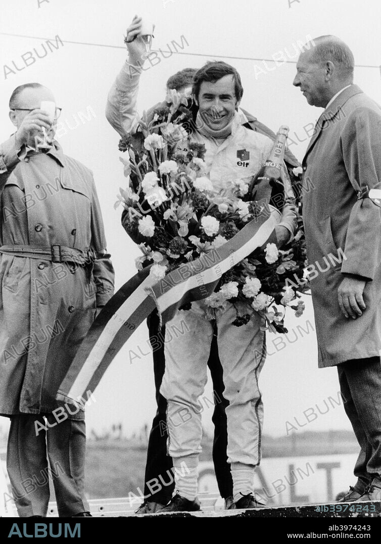 Jackie Stewart, celebrating victory at The Dutch Grand Prix, Zandvoort, 1968. Scottish motor racing driver Jackie Stewart began his Formula 1 career in 1965, winning the Italian Grand Prix in his debut season. In a career lasting until 1973, he won a then record 27 Grands Prix, as well as three World Drivers' Championships, in 1969, 1971 and 1973. After suffering a serious accident in 1966, Stewart became a prominent campaigner for improved safety in motor racing. In 1997 he returned to Formula 1 as owner of his own team.