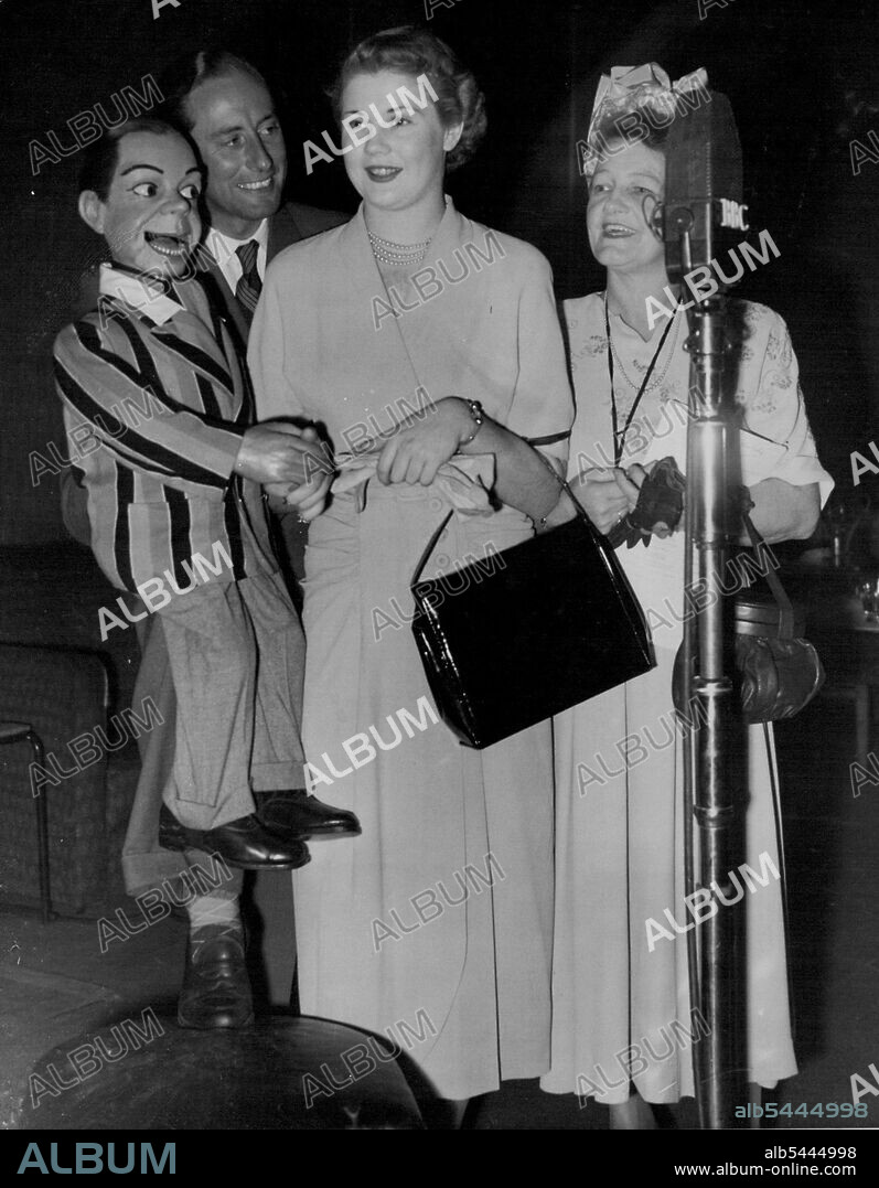 Glad You're 'In Town To-Night': Archie proves he's not so dumb as he extends an eloquent welcome to 'Miss Australia', 19 year old honey blonde Sydney model Miss Margaret Hughes in the studios at Broadcasting House, London, when she appeared on the 'In Town To-night' feature this evening (Saturday). Archie is manipulated by his master, ventriloquist Peter Brough. With Miss Hughes is her chaperone, Mrs. Joyce Snelling. Miss Australia is in London on the world tour she won as prize in a contest. June 3, 1950. (Photo by Reuterphoto).