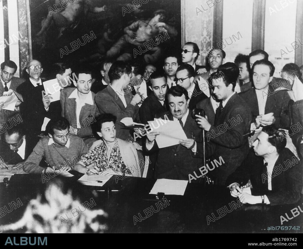Giuseppe Romita reading the provisional results of the institutional referendum. The Italian Minister of the Interior Giuseppe Romita reading in Viminal Palace the provisional results of the institutional referendum; behind him the young journalist Lello Bersani. Rome, 5th June 1946.