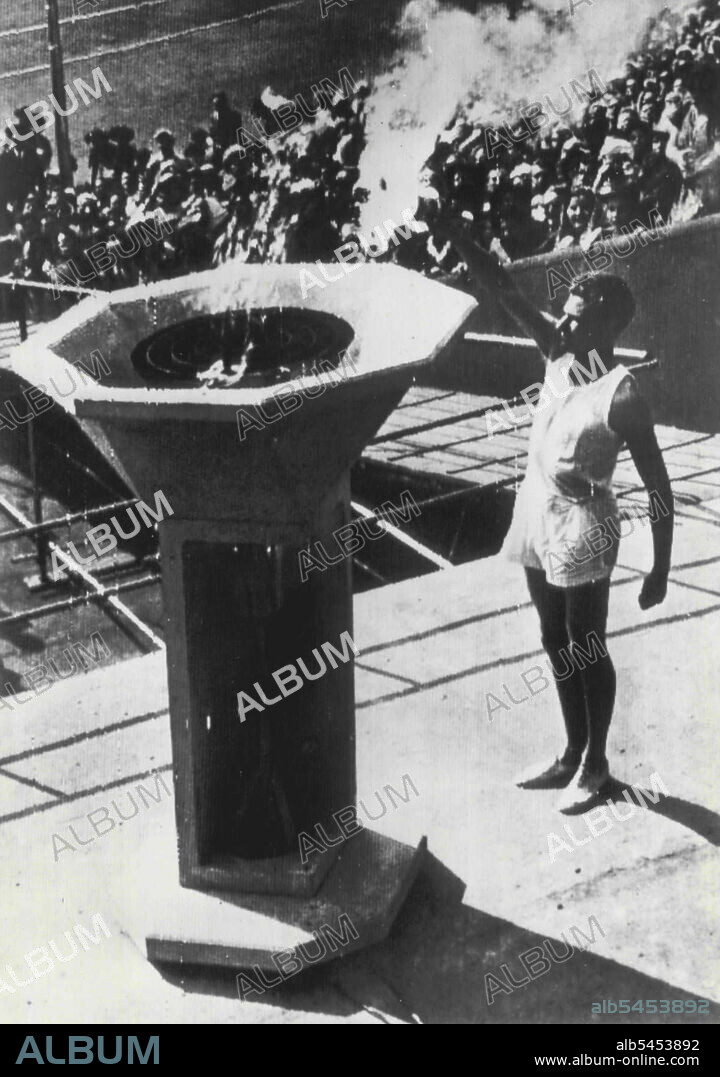 Olympic Flame Kindled - John Mark, Olympic athlete from Cambridge University, kindles Olympic flame in Wembley, England, stadium today with torch carried from Olympia, Greece, by relays of runners of Which Mark was the last. Flame arrived in stadium for ceremonies marking opening of 1948 Olympiad. July 29, 1948. (Photo by AP Wirephoto).