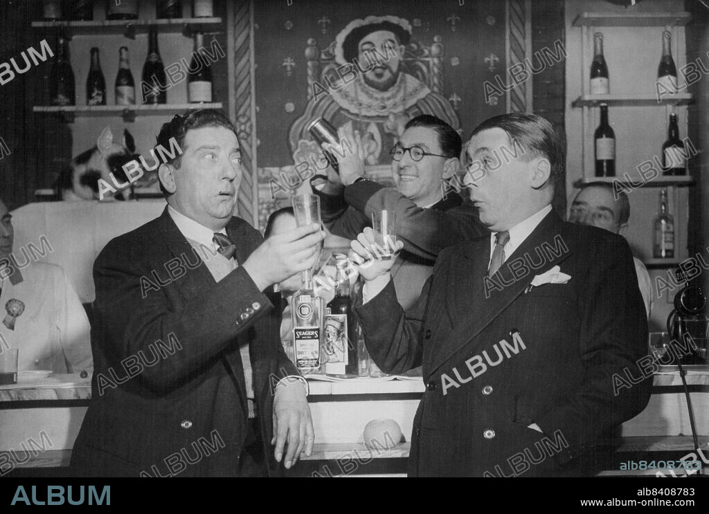 They Don't Mind If They Do!Two of the judges, Sid Fyeld (left) and Jack Train (Col. Chinstrap; "I don't mind if I do!") have a practice round with bartender Eddie Clarke at the Albany Club, London to day (Monday).A team of experts, headed by that noted connoisseur of matters alcoholic, Col. Chinstrap of Itma (Mr. Jack Train), had the enviable task of judging at to-day's Cocktail Competition organised by the United Kingdom Bartenders Guild London. March 10, 1947.