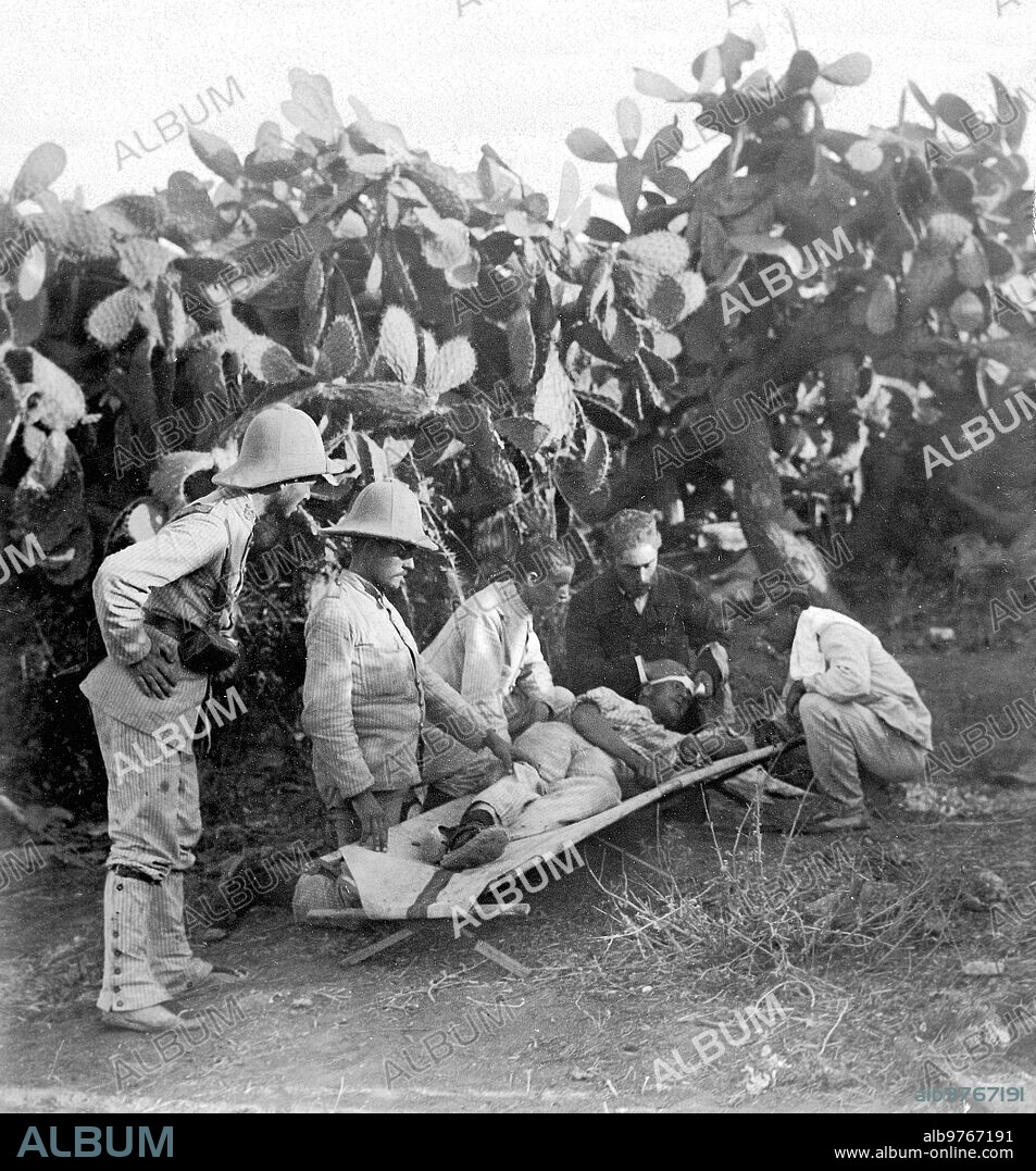 October 1909. From the battle of Zeluan. Healing of the wounded. Mr. Albeniz, correspondent in Melilla of the "Diario Universal" assisting a wounded man on the battlefield.