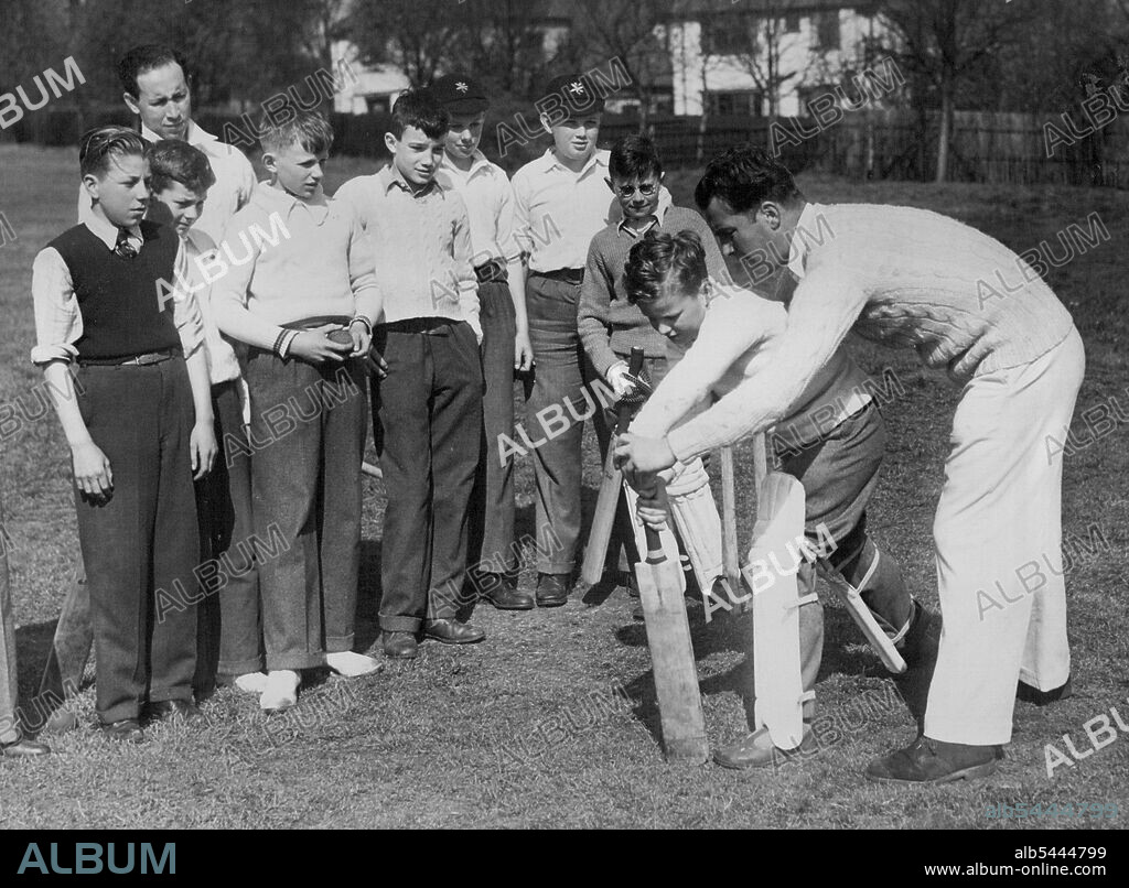 Coaching The Young Idea -- Frank Rist coaching a youthful batsman, 11-year-old John Martin, of Woodford Green, at the club. The Essex country cricket club are making the most of young talent in the district. Two of players, Frank Rist (who is also a Coachester footballer) and B. Morris, are keeping an eye on promising youngsters at the Woodford Wells Cricket club. April 21, 1948. (Photo by Fox).