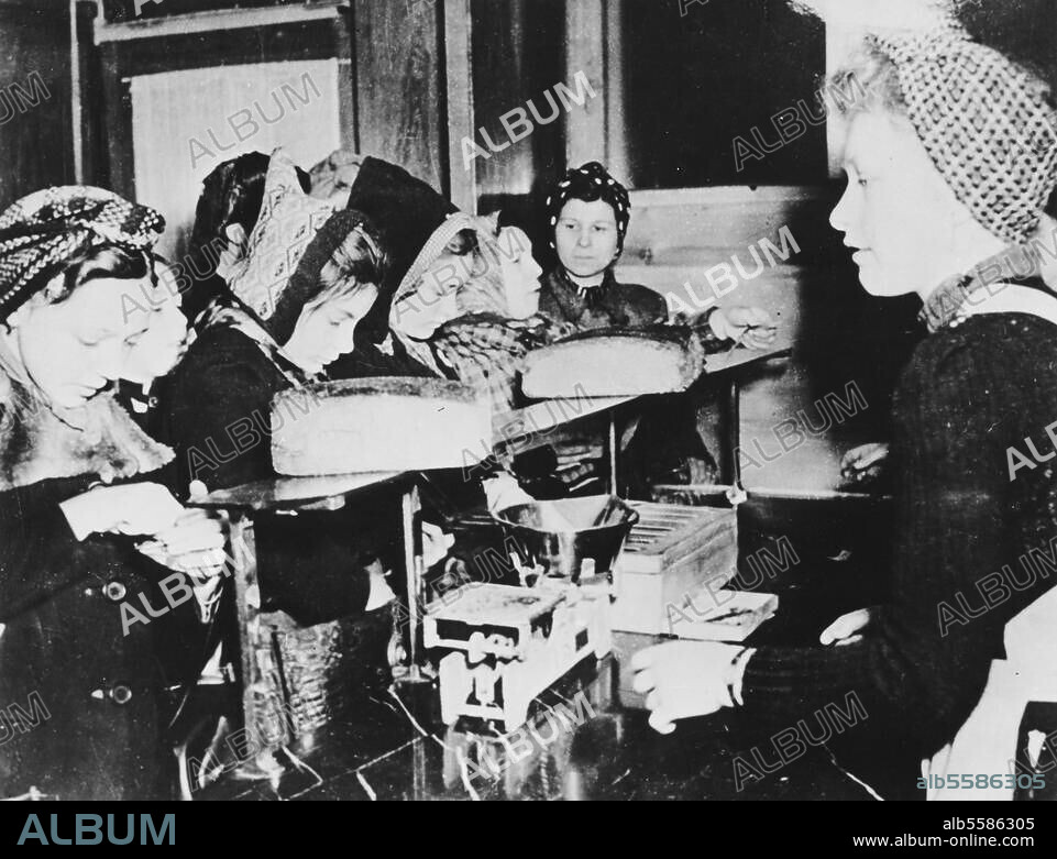 Geschichte Deutschlands 1945, Nachkriegszeit. Lebensmittelrationierung: Einkauf von Brot auf Marken. Foto, 1945.