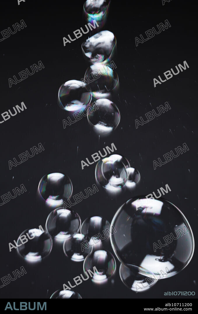 Streaming soap bubbles. Due to thin-film interference in reflected light, iridescent rainbow colors are seen.