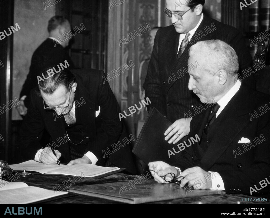 Alcide De Gasperi countersigns the Constitution. The Italian President of the Council Alcide De Gasperi countersigning the Constitution, observed by the Preident of the Italian Republic Enrico De Nicola. Rome, 27 December 1947.