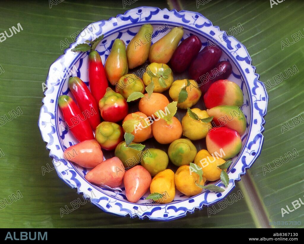<i>Luk Chub</i> are made by boiling mung bean, sugar and coconut milk into a pulp, which is then molded into fantastical shapes such as chilies, cherries, mangosteens, oranges, mangoes, watermelons, and carrots. As a finishing touch, a jelly is applied to coat the mung bean sweets to create a plastic look and texture.