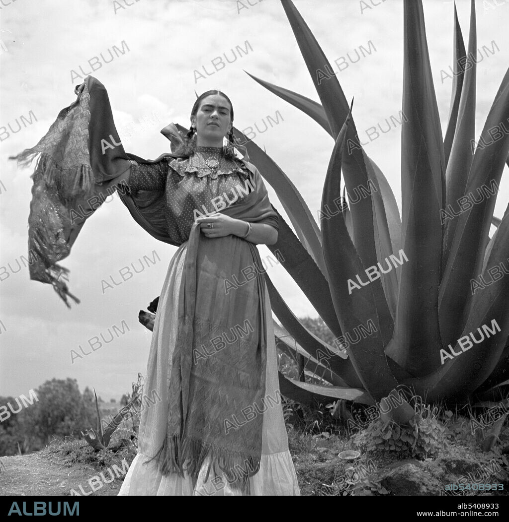 Kahlo next to an agave plant, during a photo shoot for Vogue magazine, Senoras of Mexico. Frida Kahlo de Rivera (1907 - 1954) was a Mexican artist. During the late 1920s and early 1930s, she developed her own style as an artist, drawing inspiration from Mexican folk culture, and painting mostly self-portraits which mixed elements from pre-Columbian and Catholic mythology.  Photographed by Toni Frissell, 1937.