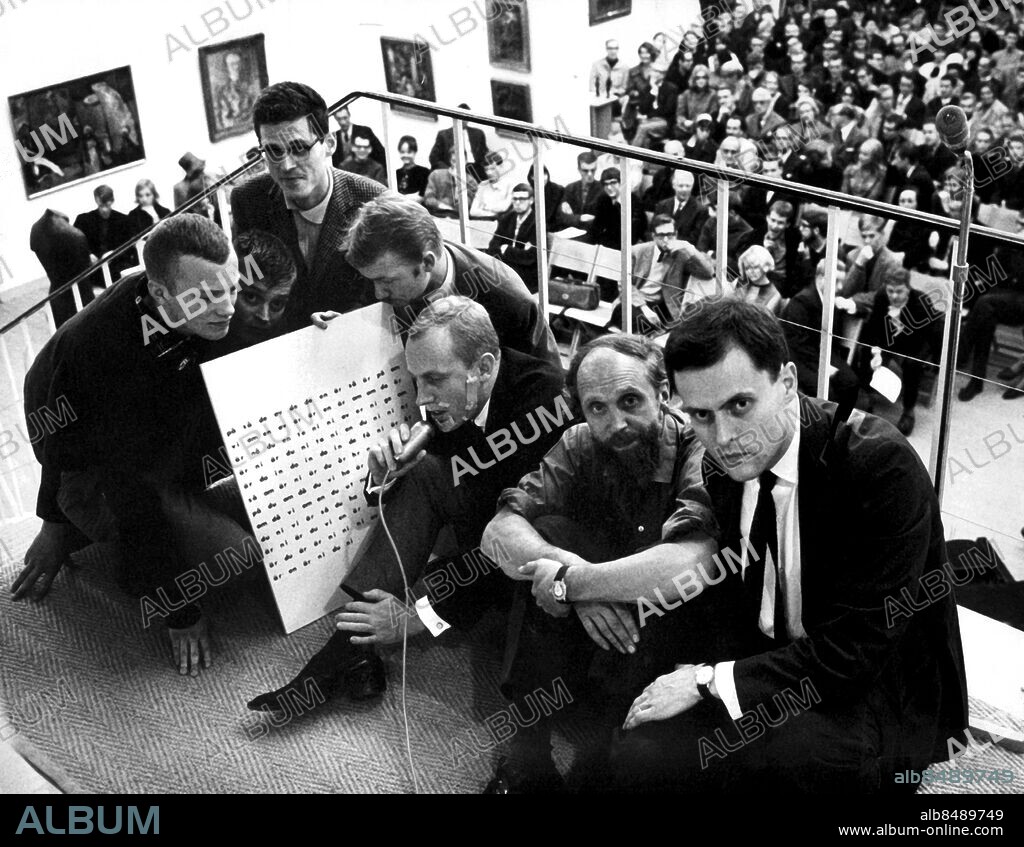 STOCKHOLM 1964-10-07 . Föreställningen "En smal kväll: Bild-Ljud-Dikt" på Moderna Museet. Bilden (fr.v.): De sju konkretisterna och en tavla före föreställningen , Mats G Bengtsson, Bengt Emil Johnson, Jarl Hammarberg, Leif Nyhlén, Carl Fredrik Reuterswärd, Åke Hodell och Öyvind Fahlström.. Foto: Ragnhild Haarstad / SvD / SCANPIX / kod. 30052.