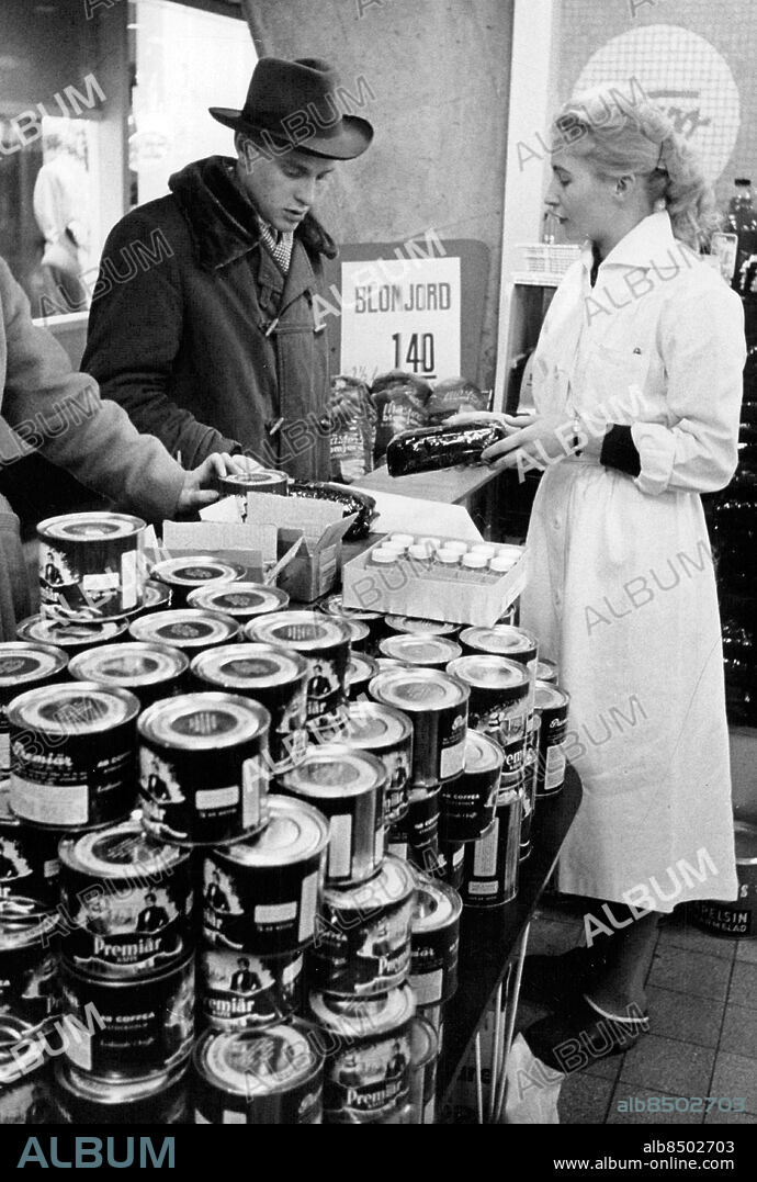 Luleå 1958-12-06. Julhandel i Luleå. Tauno Tolonen handlar kaffe av Kalsa Myllylä. I runt tal 10 000 finnar har Haparandatullen släppt igen för inköp av kaffe och julklappar. Foto: John Kjellström / SvD / TT / kod 12014.