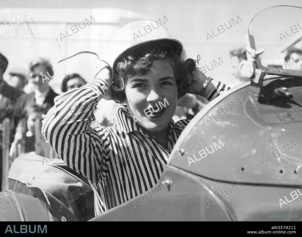The Name Is Moss -- The bright-eyed girl in the crash helmet is Pat Moss, 20, sister of ace racing driver Stirling Moss, seen getting ready for the ladies' race at Goodwood. But she was unplaced. A crash helmet is Pat Moss constant fashion in have Pat, 20, ***** of ace racing driver Stirling Moss. Here she is getting ready for a ***** race at Goodwood. June 01, 1955. (Photo by Daily Mirror).