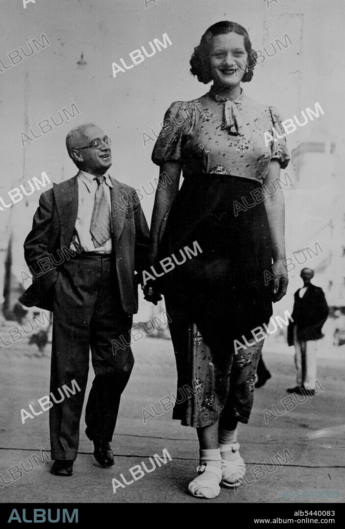 Tall Story From Vienna. Twenty-three-Year old Gisela Zambo of Hungary photographed while walking in Vienna, Austria. Her escort gives an idea of her size, which is 6ft. 9 in. September 04, 1937. (Photo by Topical Press).