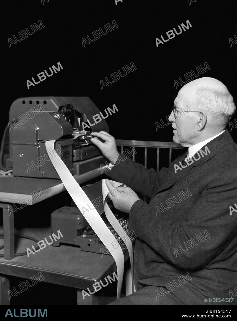 Chicago, Illinois:   June 13, 1930 One of the new ticker tape machines now being used on the new Chicago Board of Trade. A broker checks the tape.