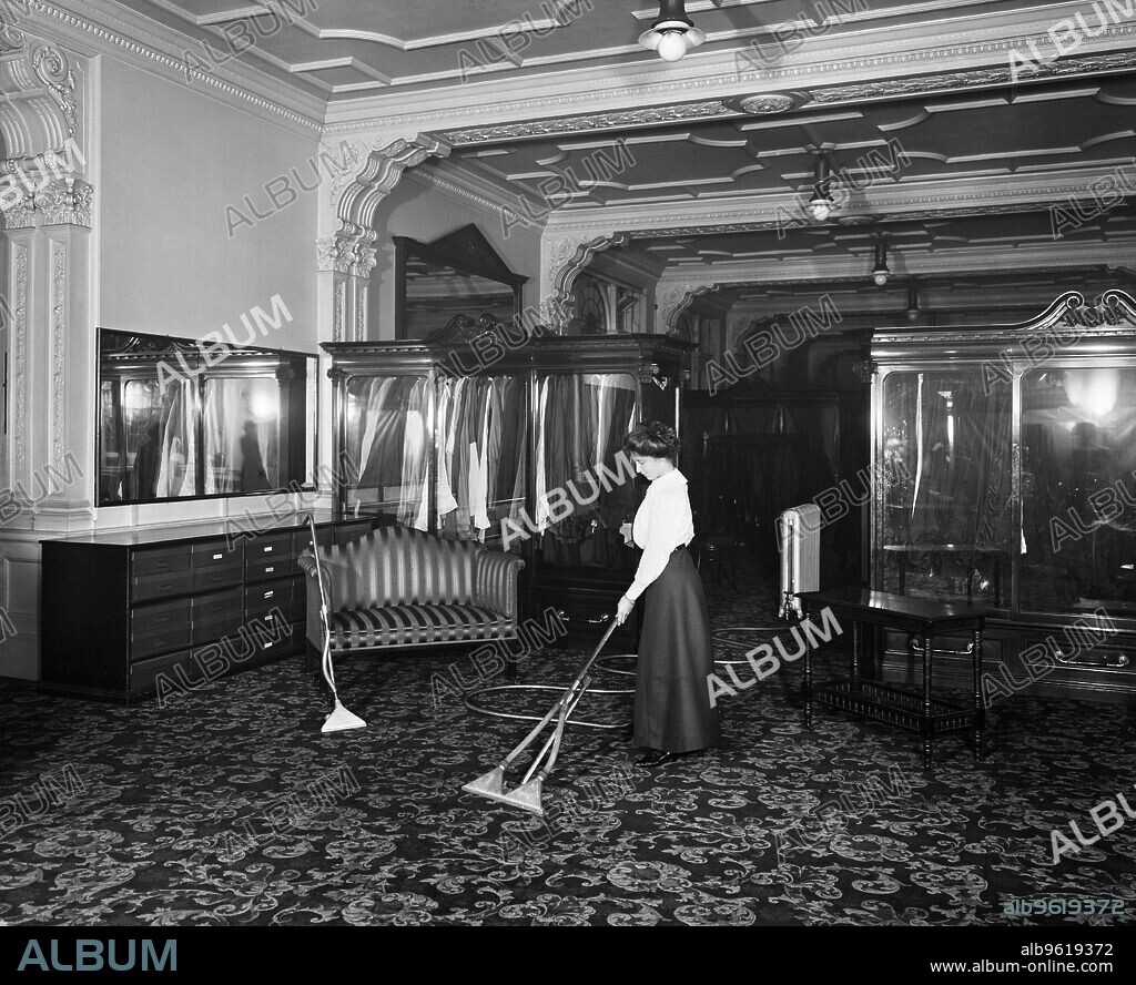 HENRY BEDFORD LEMERE. Vacuum cleaner demonstration, Frederick Gorringe's Department Store, 75 Buckingham Palace Road, London, 1910. A woman demonstrating the latest in vacuum cleaning technology. Gorringe's opened in the 1900s, but finally closed its doors in the 1960s.