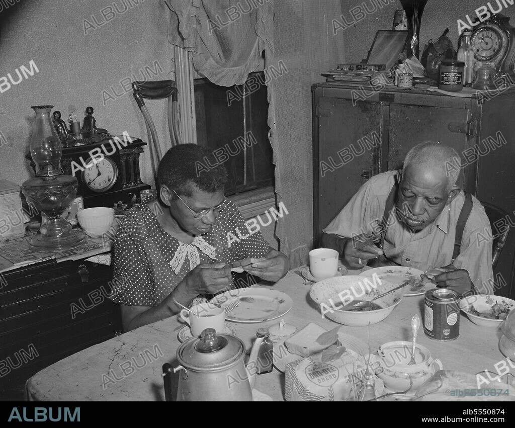 GORDON PARKS. Washington, D.C. Elderly couple eating dinner at their home on Lamont Street, N.W..