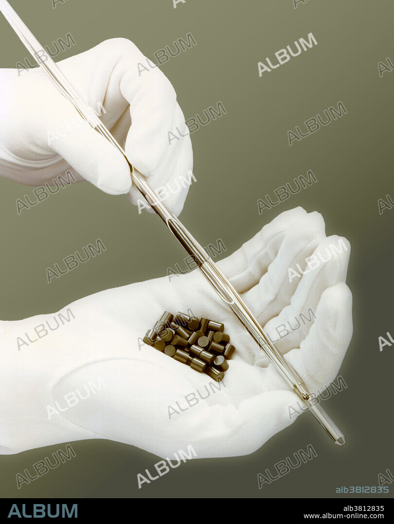 Early research into alternative energy supported by the US Department of Energy (DOE). These simulated fuel pellets and the stainless steel fuel pin illustrate the size of actual fast breeder fuel pellets. Just one of these pellets in a fast breeder reactor will produce the energy equivalent of any of the following: three tons of coal, 12 barrels of oil, 500 gallons of gasoline, or 75K cubic feet of natural gas. In use in a fast breeder nuclear reactor containing fissile uranium and plutonium surrounded by a core of non-fissile uranium-238 the reaction forms neutrons that collide with the U-238 to form fissile plutonium-239. The reaction generates more plutonium than it consumes. This photo was taken February 15, 1979 at the Fast Flux Test Facility (FFTF).