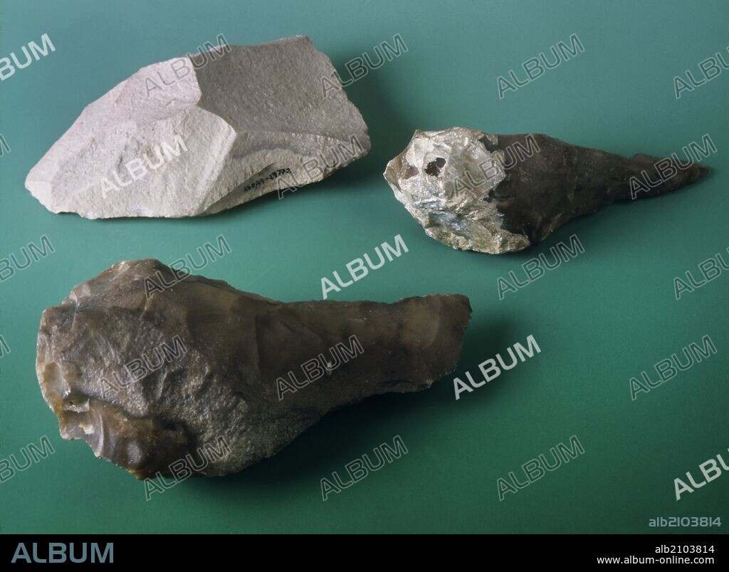 PIEZAS DE AJUAR PALEOLITICO: HENDEDOR DE CUARCITA Y DOS BIFACES MICOQUIENSES DE SILEX, PROCEDENTES DEL YACIMIENTO DE ARENERO DE SOTO (DEPOSITO: MUSEO MUNICIPAL DE MADRID).