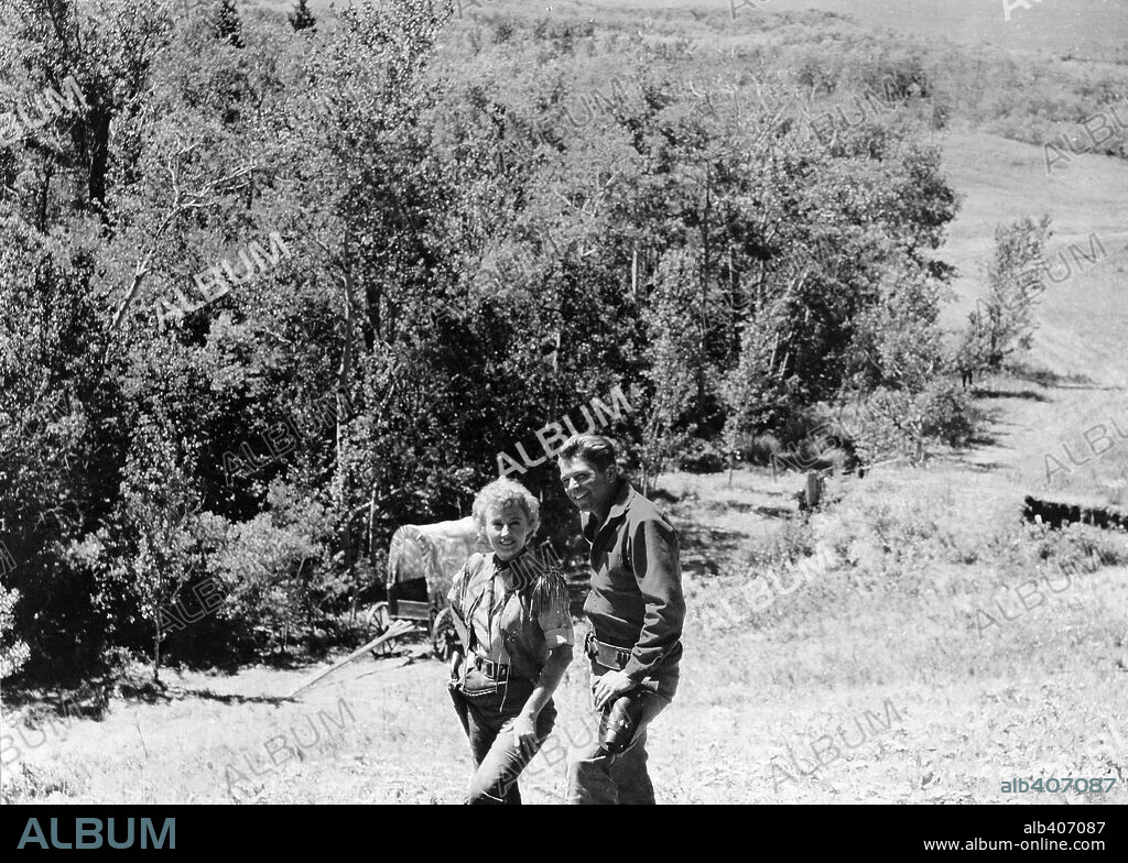 BARBARA STANWYCK and RONALD REAGAN in CATTLE QUEEN OF MONTANA, 1954, directed by ALLAN DWAN. Copyright RKO.
