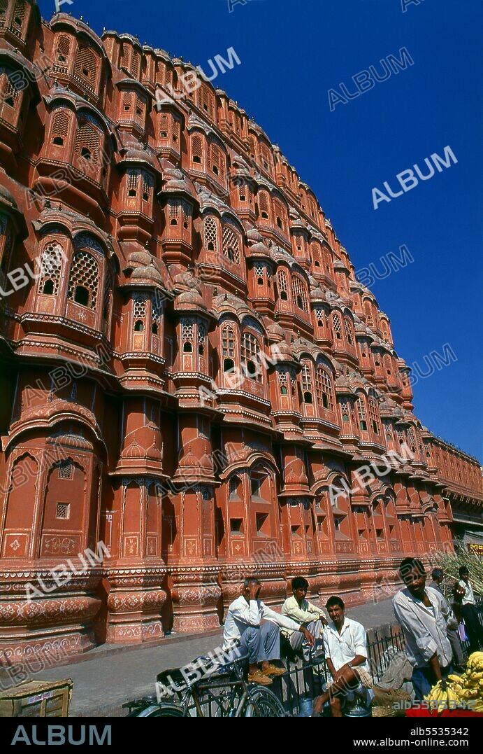 The Hawa Mahal was built in 1799 by Maharaja Sawai Pratap Singh, and designed by Lal Chand Ustad in the form of the crown of Krishna, the Hindu god. Jaipur is the capital and largest city of the Indian state of Rajasthan. It was founded on 18 November 1727 by Maharaja Sawai Jai Singh II, the ruler of Amber, after whom the city was named. The city today has a population of 3.1 million. Jaipur is known as the Pink City of India. The city is remarkable among pre-modern Indian cities for the width and regularity of its streets which are laid out into six sectors separated by broad streets 34 m (111 ft) wide. The urban quarters are further divided by networks of gridded streets. Five quarters wrap around the east, south, and west sides of a central palace quarter, with a sixth quarter immediately to the east. The Palace quarter encloses the sprawling Hawa Mahal palace complex, formal gardens, and a small lake. Nahargarh Fort, which was the residence of the King Sawai Jai Singh II, crowns the hill in the northwest corner of the old city. The observatory, Jantar Mantar, is a World Heritage Site.
