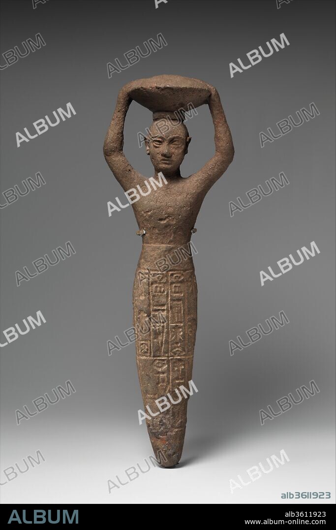 Foundation figure of Ur-Namma holding a basket. Culture: Neo-Sumerian. Dimensions: H. 27.3 cm (10 3/4 in.). Date: ca. 2112-2095 B.C..
This solid-cast figurine shows a male figure, beardless and with a shaved head, carrying a basket filled with earth above his head. The basket may indicate that the figure is participating in ceremonial building activities, such as the ceremony for making the first brick which is recorded in texts from this period. The cuneiform inscription on the peg identifies it as one which was deposited in the foundation of a temple of Inanna restored or built by the Ur III ruler Ur-Namma.