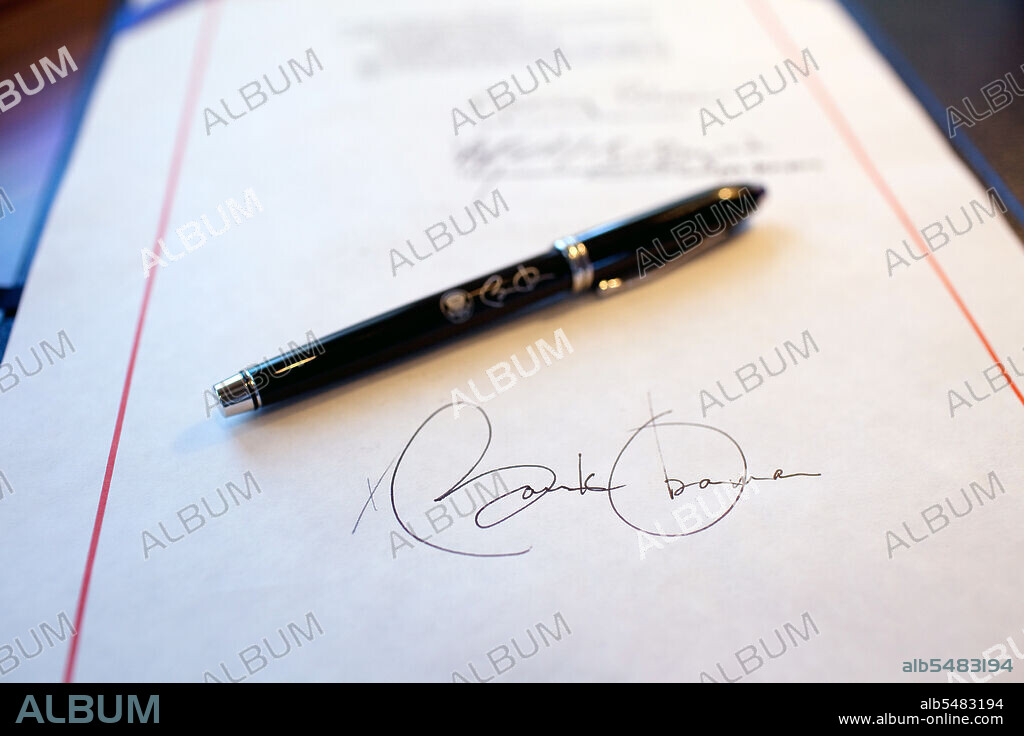 Close-up detail of President Obama's signature on a bill, and a pen used for the signing, aboard Air Force One on a flight from Buckley Air Force Base, Denver Colorado to Phoenix, Arizona 2/17/09.  .