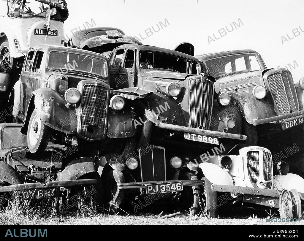 Old cars piled up in a scrapyard, Britain.