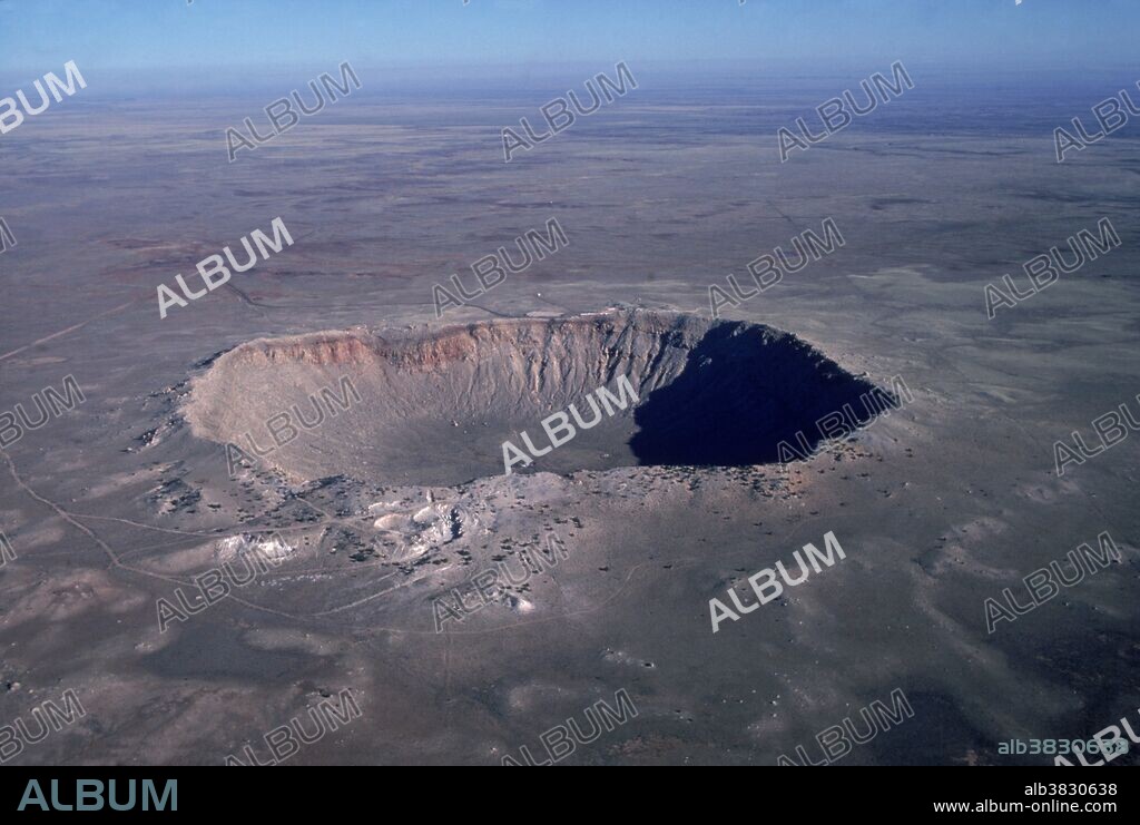 Aerial view of Meteor Crater, Arizona. It is also called the Barringer Crater, after the mining engineer who first suggested that it was formed by a meteor impact. It is about 50, 000 years old and is about 200 meters deep and 800 meters across. Several attempts to mine the iron- rich material of the meteor were made before a visitor center was built in the 1960's. Two new minerals - coesite and stishovite - were identified here; both are forms of silica created at high temperatures and pressures. In recent years the crater has been used for astronaut training & studies in planet comparison.