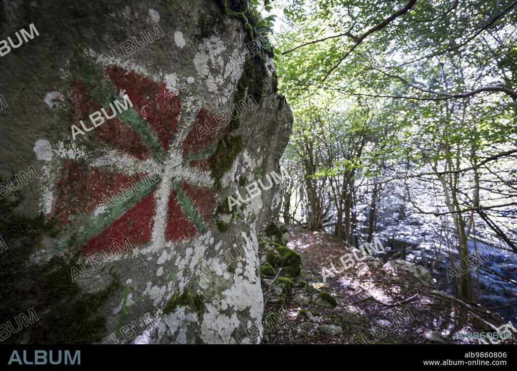 Basque flag painted on the rock, ikurrina, GR 20 trail - Circular route to Aralar, Aralar natural park, Guipuzcoa-Navarra, Spain.