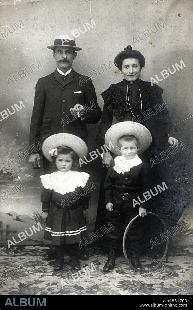 Portrait de famille, les parents et les deux enfants, un garcon et une fille, Photographie anonyme, annees 1900. au dos : " Je vous envoie tte la famille. Nous faisons tous de droles de grimaces mais enfin ça vous donne tt de mm un aperçu. Les petits sont mieux tous les deux, ils sont bien ressemblants..." Famille petite bourgeoisie. Tirage argentique. Credit Collection KHARBINE TAPABOR.