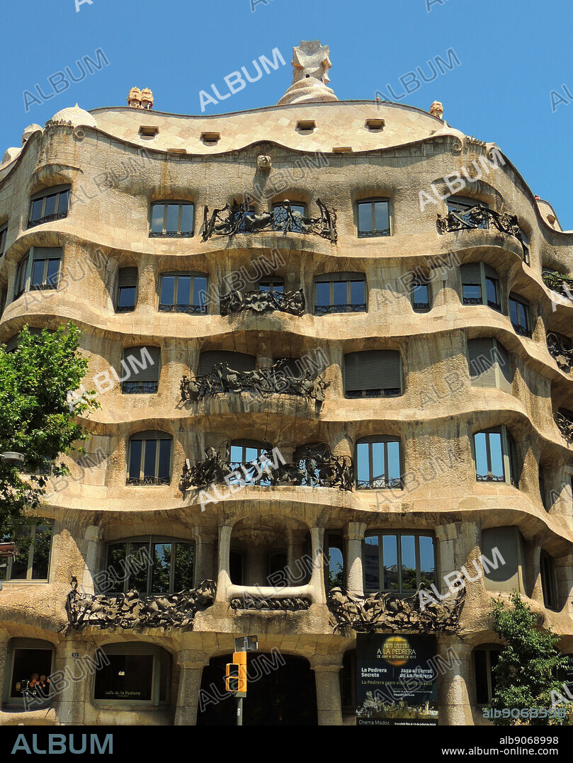 the facade of Casa Milà known as La Pedrera (meaning the 'The Quarry')is a building designed by the Catalan architect Antoni Gaudi and built during the years 19061912. It is located at 92, Passeig de Gràcia (Passeig is Catalan for promenade) in the Example district of Barcelona, Catalonia, Spain. It was a controversial design at the time for the bold forms of the undulating stone facade and wrought iron decoration of the balconies and windows, designed largely by Josep Maria Jujol, who also created some of the plaster ceilings.