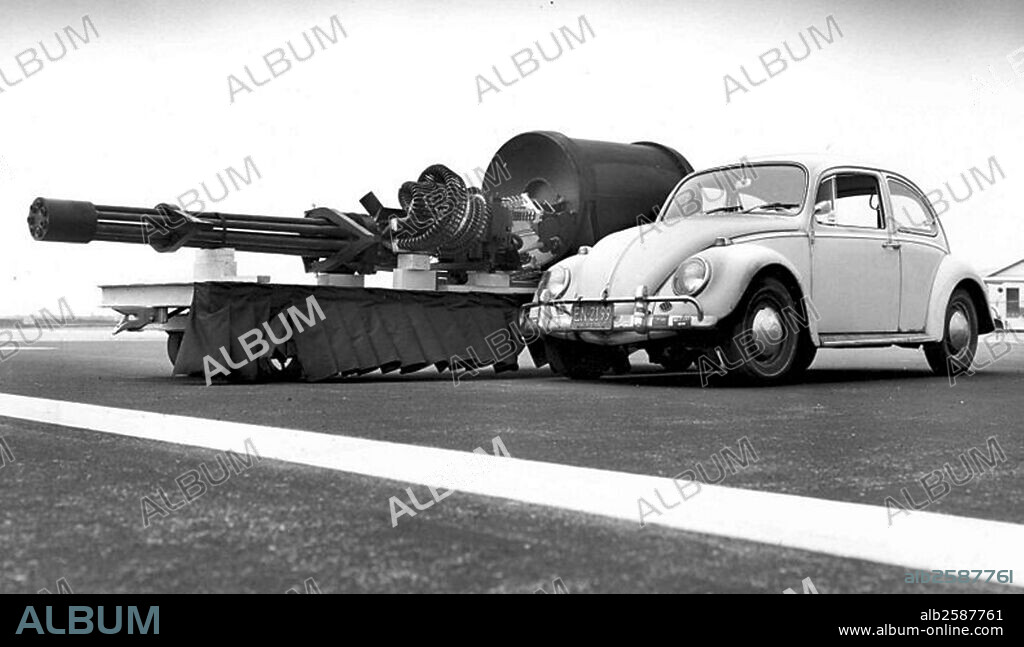 Photograph of a General Electric GAU-8/A displayed next to a Volkswagen Beetle for size comparison. Dated 1960 .