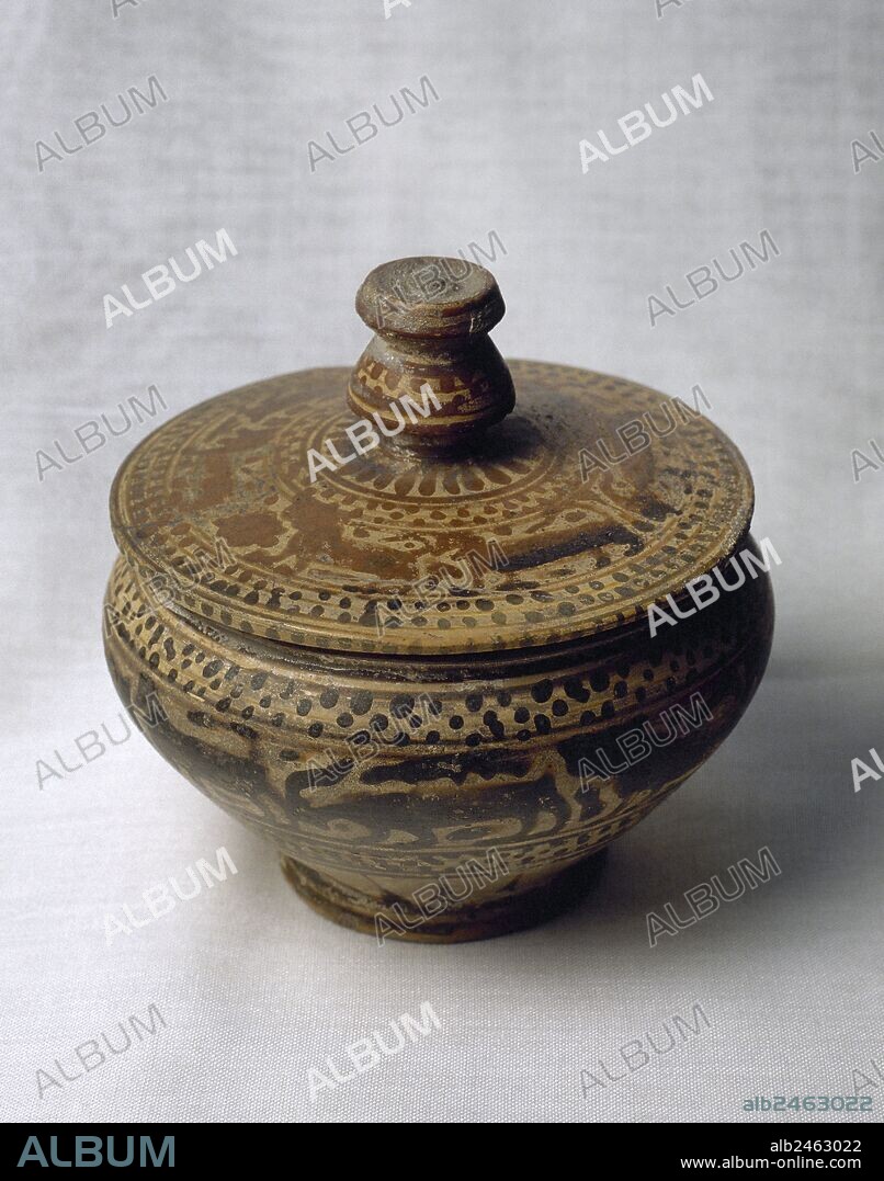 ARTE GRIEGO. SIGLOS VII-VI a. C. PIXIDE de forma troncocónica y tapa circular. Decorada con motivos geométricos entre figuras de leones y ciervos en hilera. Tiene 110 mm. de altura y 105 mm. de diámetro. Procede de Corinto (Grecia). Museo del Perfume. Barcelona. Cataluña.
