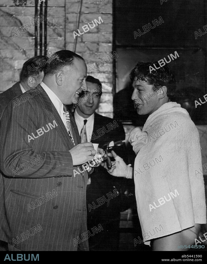 Jack Solomons's Gym. Jack Solomons, tea cup and inevitable cigar in hand, exchanges a crack with fighter Eric Boon. April 4, 1948. (Photo by Pictorial Press).