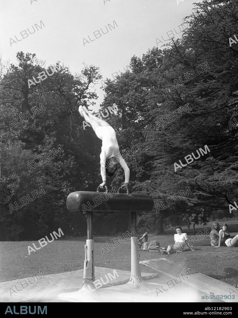 Over in Style American Girl gymnasts practice in brilliant sunshine. Miss Clara Schroth from Philadelphia , member of the United States Womens Gymnastics team for the Olympic Games , training on the lawn of the Olympic Centre at Southlands College Wimbeldon. 28th July 1948.