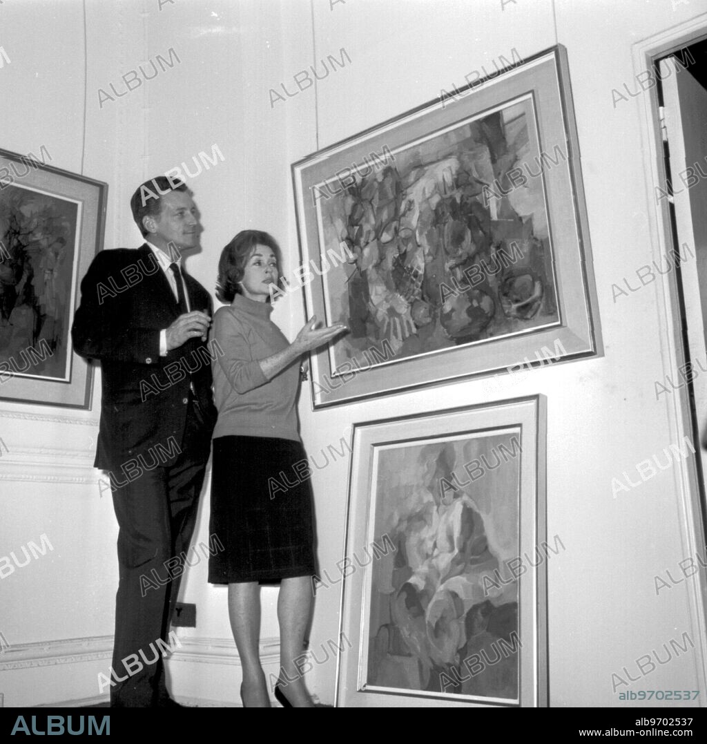 A one woman art show devoted to the actress Lilli Palmer at the Galleries of Arthur Tooth & Sons, in London. She is shown here with her husband Argentine actor Carlos Thompson. 6th December 1965.