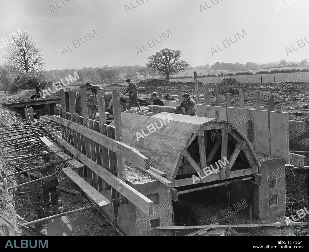 JOHN LAING PLC. Laing workers constructing a concrete arched culvert in Section C2 of the M1, the London to Yorkshire Motorway. Section C of the London to Yorkshire Motorway is between Gayhurst and Kislingbury in South Northamptonshire. The caption beneath the corresponding album print reads '7'6" span arch culvert built in mass concrete in three stages. Location: chainage 22,000.'.