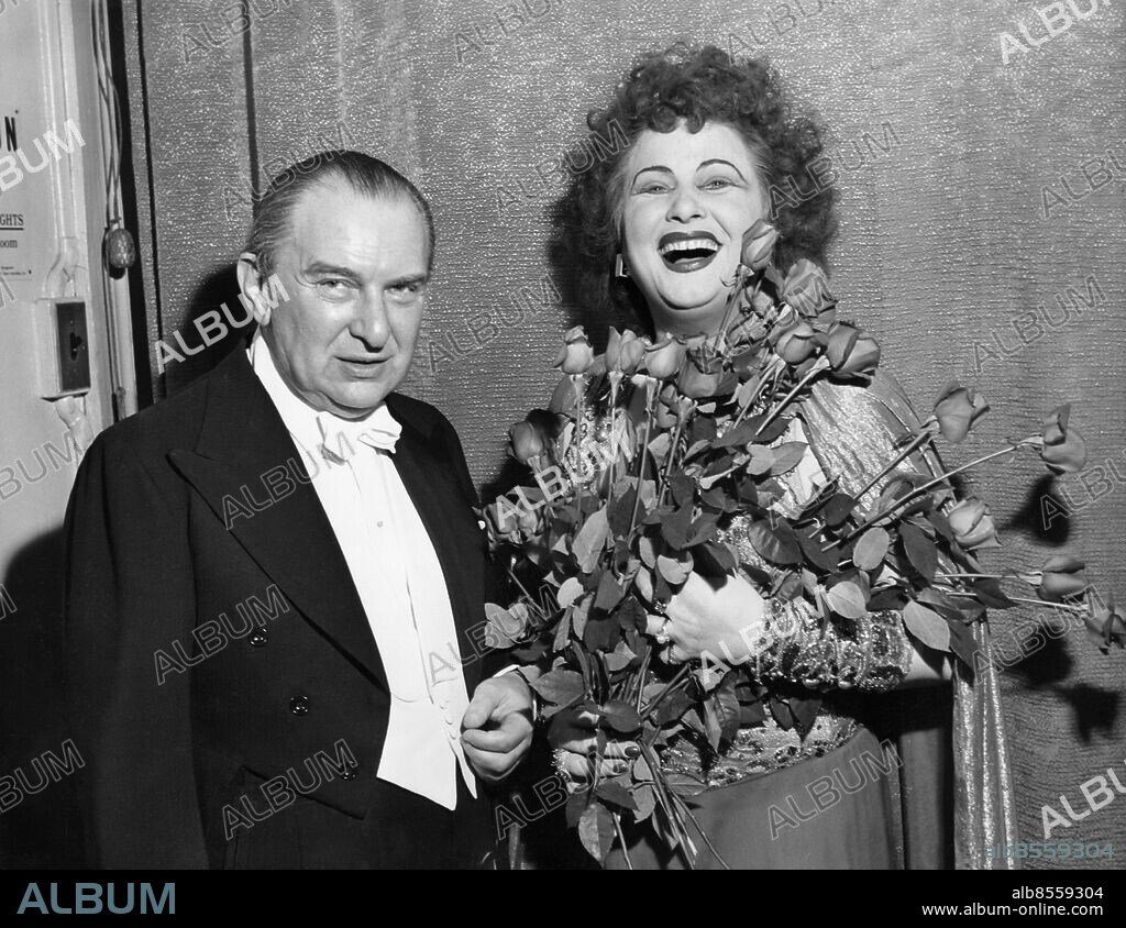 Orig. bildtext... DOUBLE DEBUT New York. Famous conductor Fritz Reiner, and Ljuba Welitsch, bulgarian soprano from the Vienna State Opera, are shown in her dressing room at the Metropolitan Opera House after last night*s production of Richard Strauss' Salome. It was a double debut for opera fans as both Mr. Reiner and Miss Welitsch made their initial appearances at the famous opera house. Anm. Buketter Dirigenter Smink Ögonbryn Leenden Läppar Jämförelser Ansiktsuttryck persons: LJUBA WELITSCH;FRITZ REINER sites: NEW YORK;USA.
