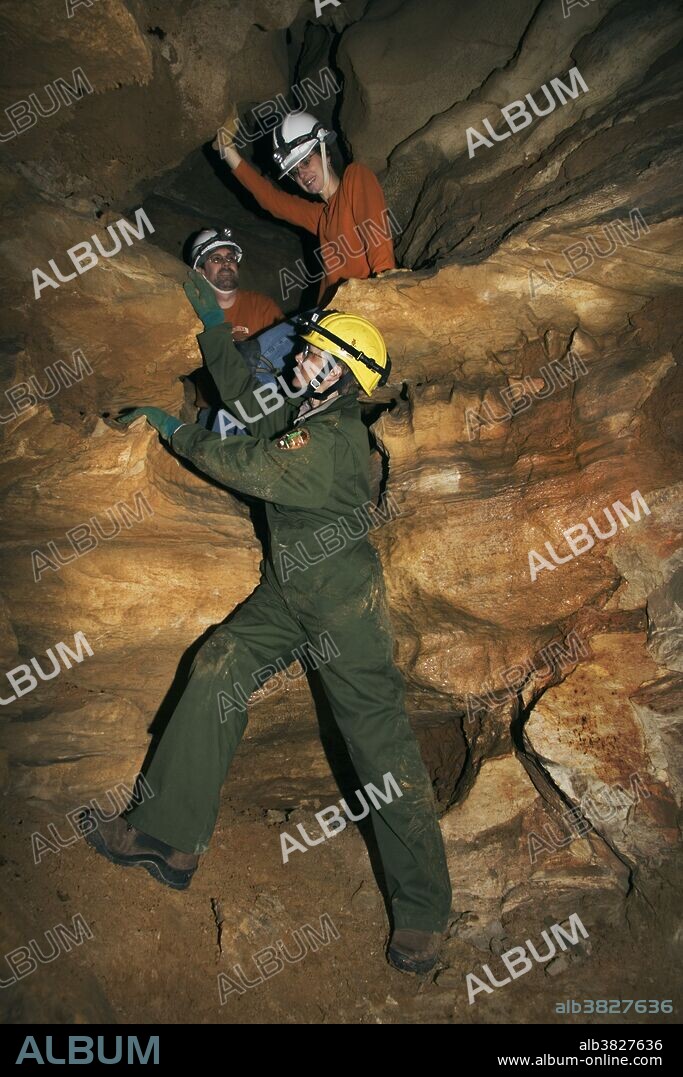 A park ranger and visitors climbing during a wild cave tour, Mammoth Cave National Park, Cave City, Kentucky.