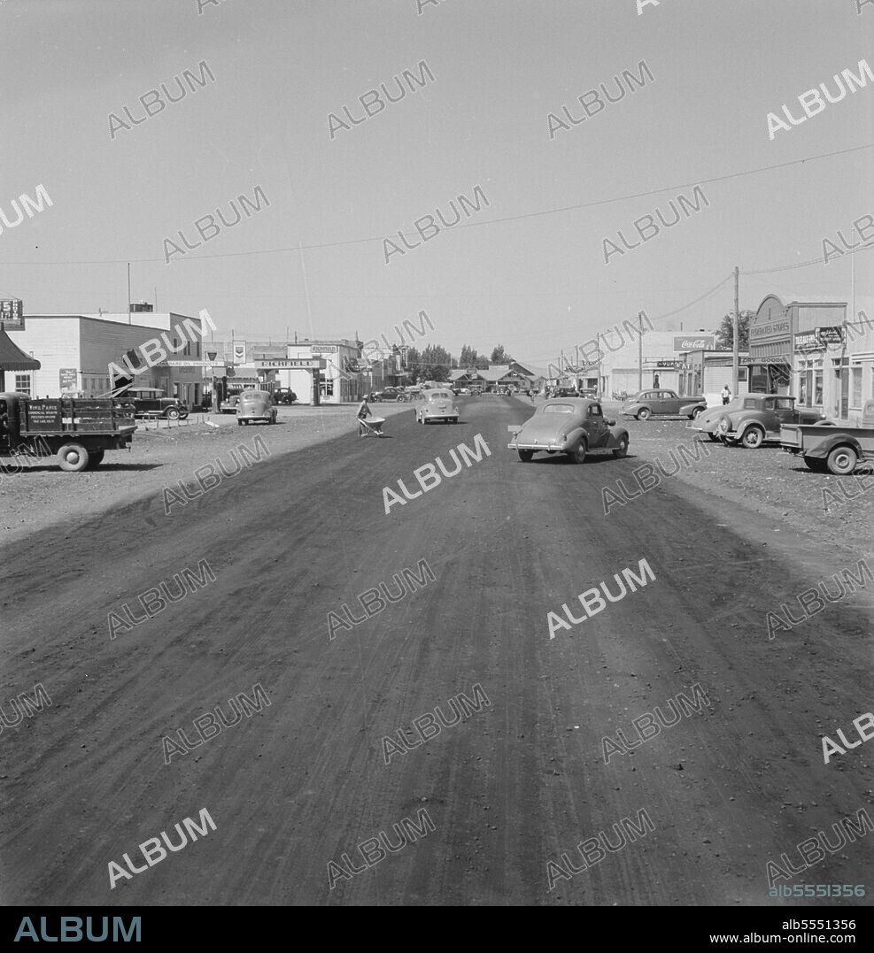 DOROTHEA LANGE. California Siskiyou County, Tulelake. Looking down main street of a frontier town, still impaired. This town has no safe drinking water. [Signs: 'Standard Oil Products; Richfield; Casino; Coca-Cola; Federated Stores; Dry Goods; Mildred's Beauty Salon'].