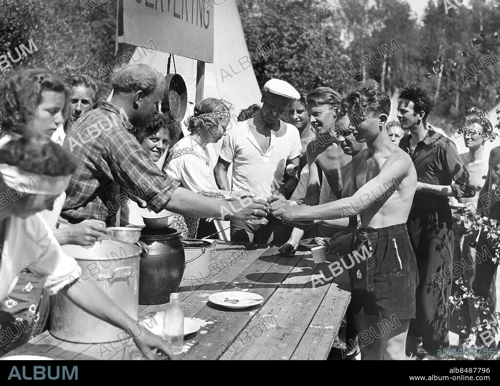 TOLLARE 1939-06-10.. Några frisksportare blir serverade kruskagröt under vistelse vid Tollare. Not. Utdelning av kruska. Tollare.. Foto: AB Text & Bilder / SVT / Kod: 5600. Mapp: Frisksport 3819 B . Bildserier Fotoreportage Läger för frisksportare Gröt.