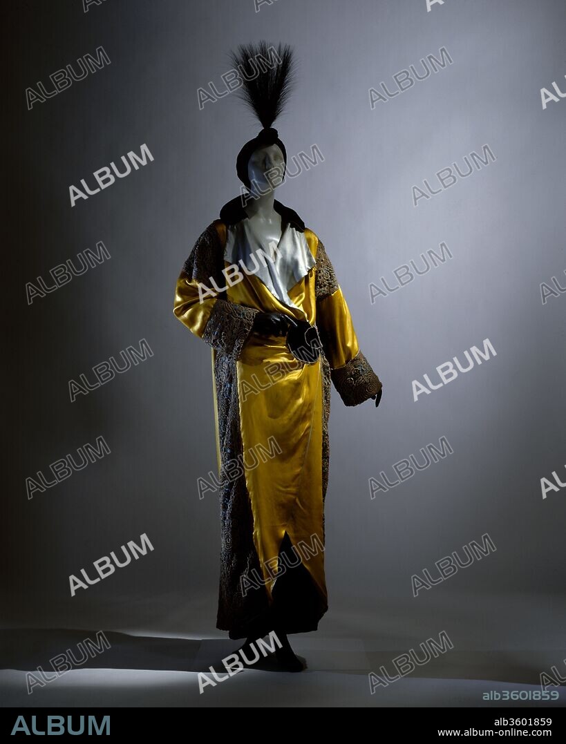 Opera coat. Culture: French. Designer: Paul Poiret (French, Paris 1879-1944 Paris). Date: 1912.
This opera coat of yellow and pale blue silk satin, black silk velvet, turquoise silk satin with gold and silver filé crocheted overlay, and silver filé trapunto half-belt and trim was interpreted by the illustrator George Lepape, whose album  Les choses de Paul Poiret was exhibited at the Galerie Barbazanges, a commercial gallery on the premises of Poiret's couture house.  The charming renderings of  Lepape in Les choses de Paul Poiret (and later in the Gazette du bon ton) conveyed a contextual reality to Poiret's exquisite creations.  Comparing extant costumes to their representation, however, often reveals that accuracy was sometimes sacrificed for dramatic intention.  Nevertheless, Lepape's subtle stylistic elisions and exaggerations imbue Poiret's fashions with a beauty less seductively conveyed by the harsher documentary evidence of photography.