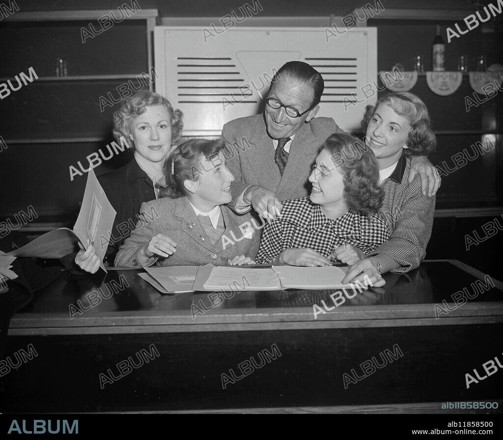DAME ASKEY AND DAUGHTER GET READY FOR PANTOMIME. Comedian ARTHUR ASKEY -just back from Australia -and his daughter Anthea pictured with other members of the cast as they started the scripts for the first rehearsal of the Christmas pantomime ' Goody Two Shoes ' at the Casino Theatre, Old Compton Street, London . Left to right: Magda Neeld (Very Good Hope); Anthea Askey (Twiggy); Arthur Askey (Dame); Yvonne Marsh (Goody Two Shoes) and Joy Hayden (Robbie Goodfellow ). Eighteen-year-old Yvonne Marsh was chosen Britain's perfect schoolgirl in 1949, has already scored success on films and television. 4 December 1950.