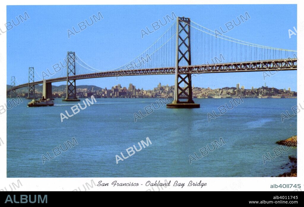 San Francisco-Oakland Bay Bridge, California, USA, 1957. Vintage postcard showing the San Francisco-Oakland bridge spanning San Francisco Bay. The city skyline is in the distance. Designed by Charles H Purcell, the Bay Bridge opened to traffic in 1936, six months before the Golden Gate Bridge.